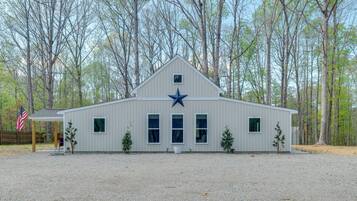 A building with a star emblem, a covered area with an American flag, and a gravel driveway.
