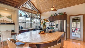 A modern kitchen with a large island, wooden cabinets, and a view of the outdoors. - Fun w/ Family! Lakefront Gem in Jamestown (Jamestown)