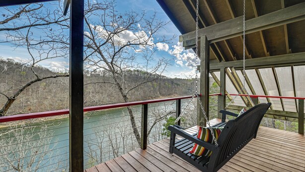 A wooden deck with a swing chair, a railing, and a view of a river and forest. - Fun w/ Family! Lakefront Gem in Jamestown (Jamestown)