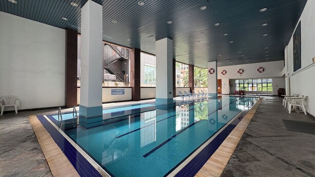 An indoor swimming pool with clear lanes, a tiled floor, and a ceiling with recessed lighting. - The Maple Suite by Manhattan (Kuala Lumpur)