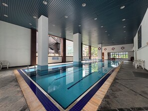 An indoor swimming pool with clear lanes, a tiled floor, and a ceiling with recessed lighting. - The Maple Suite by Manhattan (Kuala Lumpur)