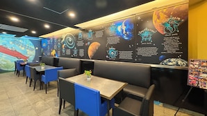 A restaurant with booths and tables, a mural with celestial bodies, and informational text about zodiac signs. - The Maple Suite by Manhattan (Kuala Lumpur)