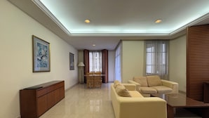 A spacious living area with a sofa, a dining table, and a cabinet. - The Maple Suite by Manhattan (Kuala Lumpur)