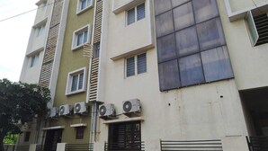 Un edificio de varios pisos con fachada plana, varias ventanas y unidades de aire acondicionado.