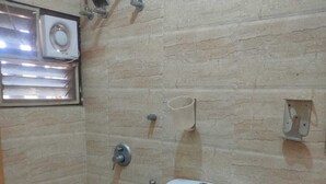 Un baño pequeño con inodoro, bidé y ventana con persianas.