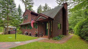 Eine Holzhütte mit Veranda, einer Flagge und einem 'Welcome'-Schild.