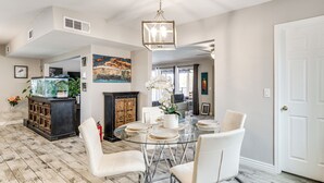 A dining area with a glass table, white chairs, and a decorative centerpiece. - Saguaro Retreat! Extended Stay in Tucson (Tucson)