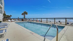 A swimming pool with a 3ft depth marker, adjacent beach chairs, and a palm tree. - Walk to Pool & Beach! 3rd-Floor Murrells Inlet Gem (Murrells Inlet)