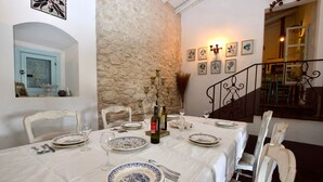 A dining area with a stone wall, a staircase, and a view of the interior. - Villa in Chiaramonte Gulfi with 3 bedrooms sleeps 8 (Chiaramonte Gulfi)