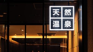 A building entrance with a sign featuring Chinese characters. - SUPER HOTEL Kirishima Natural Hot Spring (Kirishima)