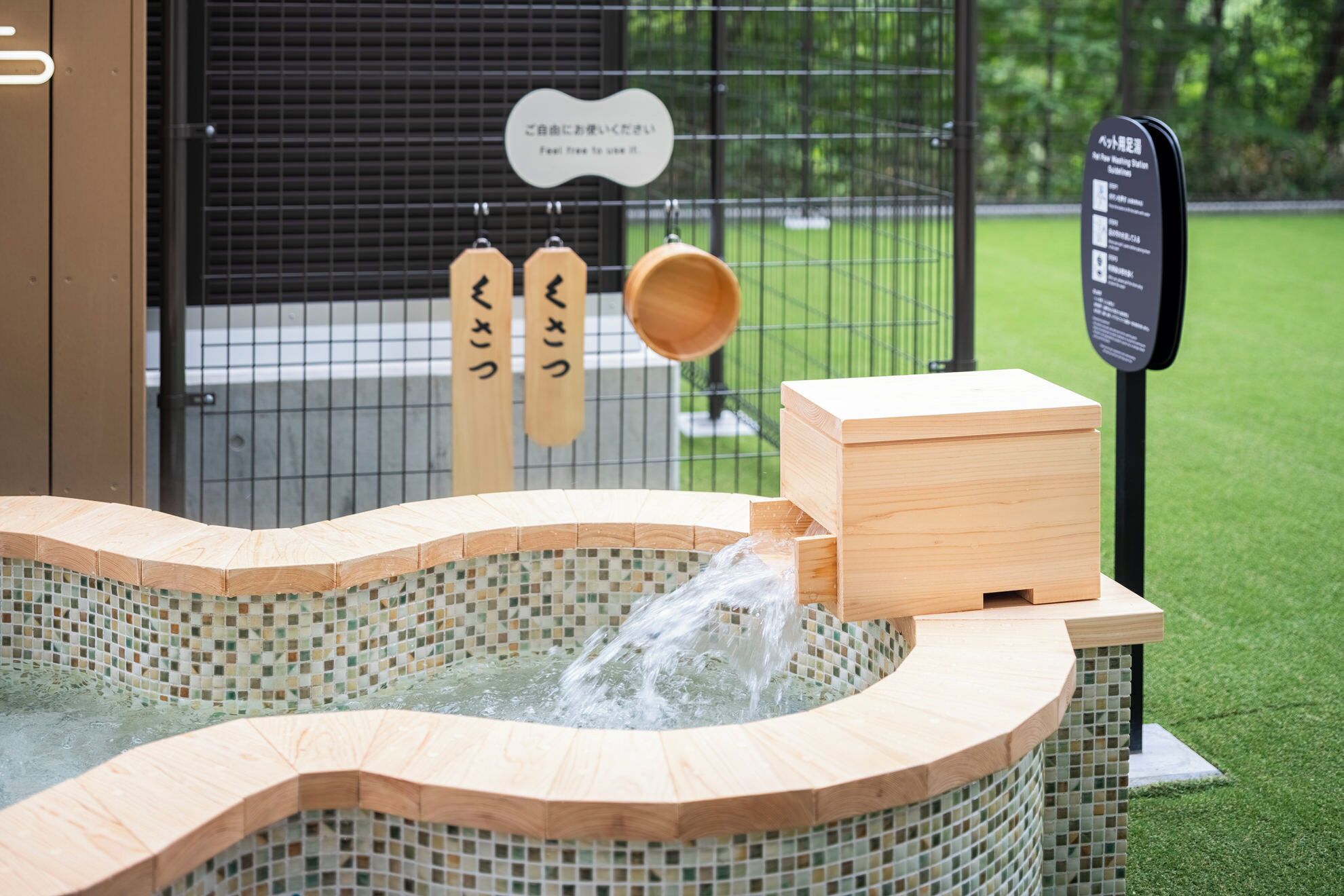 A hot spring bath with wooden railings and a tiled interior.