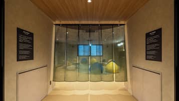 A room with a wooden ceiling, a large window with a view, and two informational plaques on the walls.