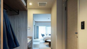 Een hotelgangen met een houten kast, een bed, een bureau en een badkamer.