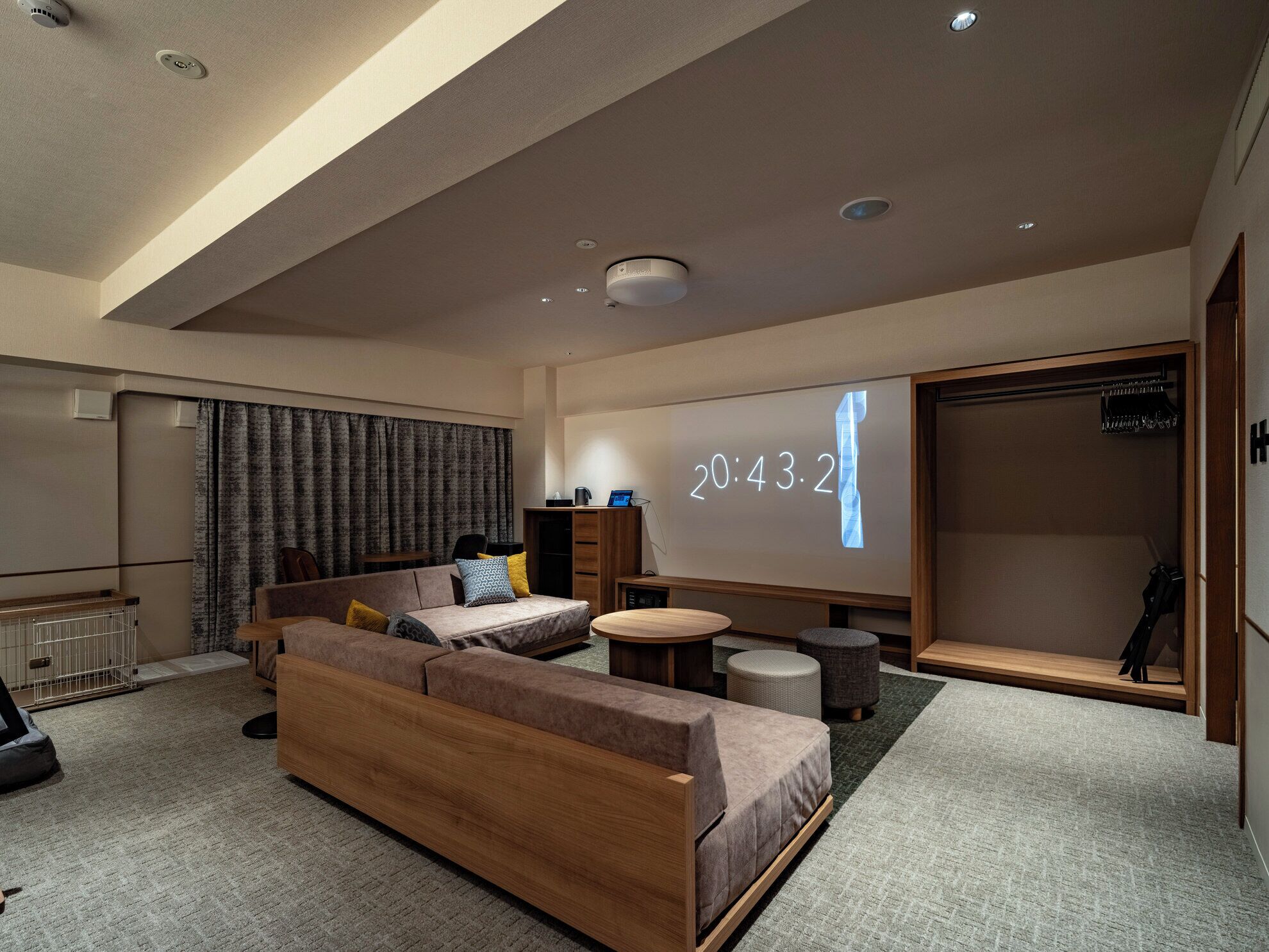 A modern living room with a sofa, coffee table, and a projection screen displaying the time.