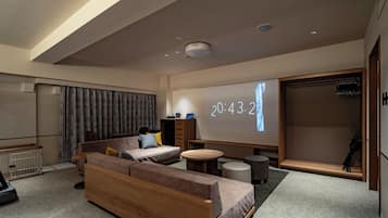 A modern living room with a sofa, coffee table, and a projection screen displaying the time.