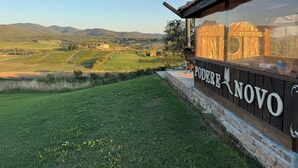 A building with a view of rolling hills and vineyards. - Podere Novo (Bibbona)
