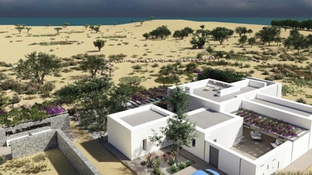 A modern building with a flat roof, surrounded by a desert landscape with sparse vegetation and a clear sky. - Villa Lemoni – Walk to the Beach (4798+R23 Xifara, Greece)