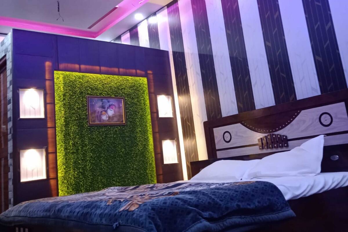 Un dormitorio con una cama, un cuadro colgado en la pared, una pared verde con un cuadro y una pared a rayas.