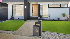 A modern two-story house with a large front door, a small front porch, and a well-maintained lawn. - Modern Luxe Haven – Your Geelong Escape (Highton)