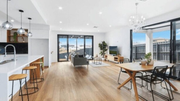 A modern kitchen with a dining area, large windows, and a view of the city. - Modern Luxe Haven – Your Geelong Escape (Highton)