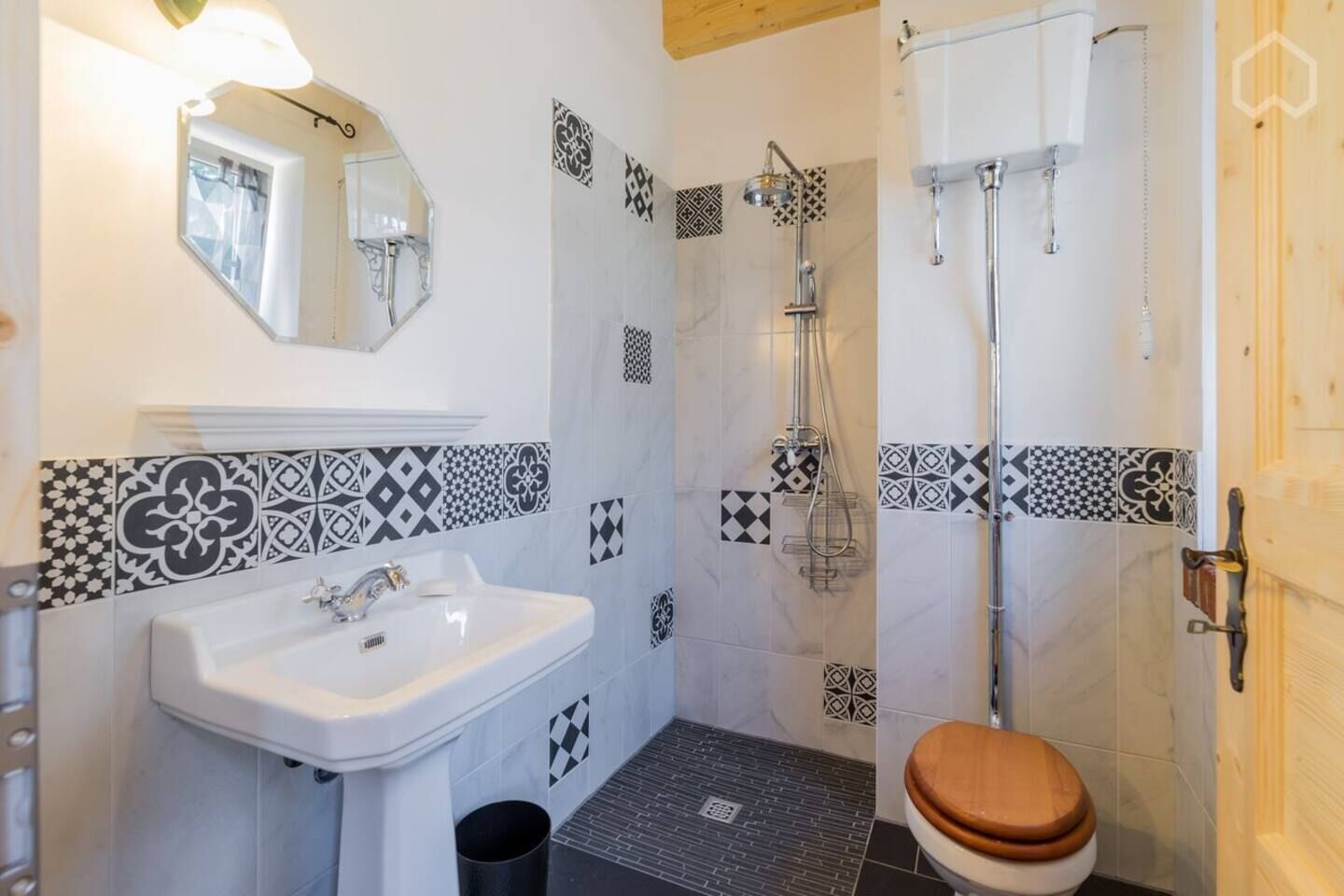 A bathroom with a sink, mirror, shower, and toilet.