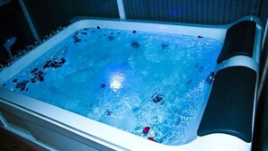 A hot tub with water, bubbles, and rose petals. - Hotel Bella Vista (Anuradhapura)