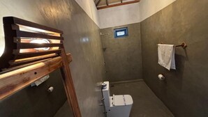 A compact bathroom with a shower, a toilet, and a towel rack. - Hotel Bella Vista (Anuradhapura)
