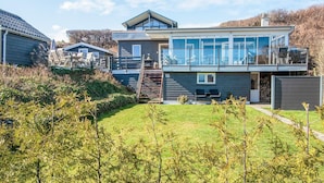 A modern two-story house with a large glass balcony, a visible number '15' on the side, and a well-maintained lawn. - 4 Star Holiday Home in Hejls (Hejls)