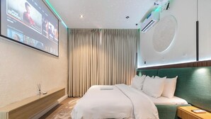 A modern hotel room with a large bed, a wall-mounted TV, a ceiling with star-like lights, and a large window with curtains. - Mildy Lodge And Apartment  (Abuja)