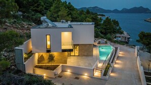 A modern house with a swimming pool, surrounded by trees and a view of the sea. - Villas Mare & Luce (Pijavičino)