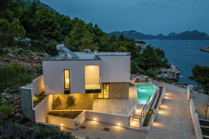 A modern house with a swimming pool, surrounded by trees and a view of the sea. - Villas Mare & Luce (Pijavičino)