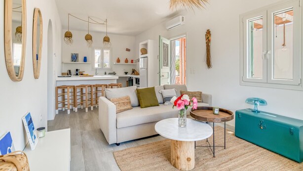 Ein modernes Wohnzimmer mit einer Couch, einem Couchtisch und Barhocker.