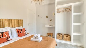 Ein Schlafzimmer mit Bett, Kleiderschrank und einer Pendelleuchte.