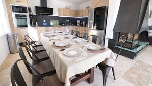 Une cuisine moderne dotée d’appareils électroménagers intégrés et d’un coin repas aménagé pour accueillir six personnes.