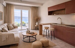 A modern living room with a sofa, coffee table, and ottomans, a kitchen with a sink and stools, and a large sliding glass door with a view. - Amazing home in Sainte-Maxime (Sainte-Maxime)