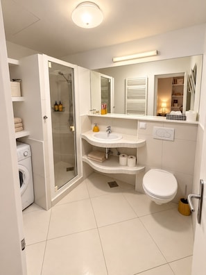 A modern bathroom with a glass-enclosed shower, a white sink, and a toilet. - House Dalma (Dubrovnik)