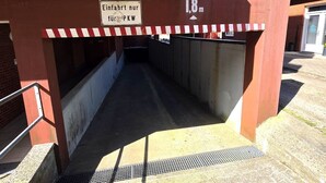 Überdachter Fußweg mit Schild, das eine Höchsthöhe von 1,8 Metern angibt.