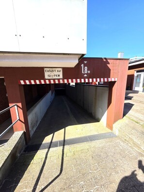 Une passerelle piétonne couverte, agrémentée d’un panneau indiquant une hauteur maximale autorisée de 1,8 mètre.