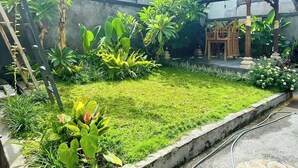 Um jardim com diversas plantas e uma estrutura de madeira.