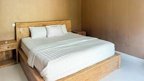 Quarto com estrutura de cama de madeira, roupa de cama branca e mesa de cabeceira.