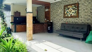 Uma sala de estar moderna com um sofá, televisão, lareira e parede de pedra.