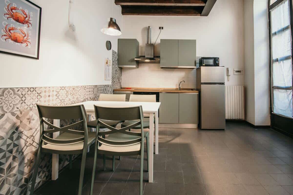 A modern kitchen with a dining area, featuring a table, chairs, and a microwave.