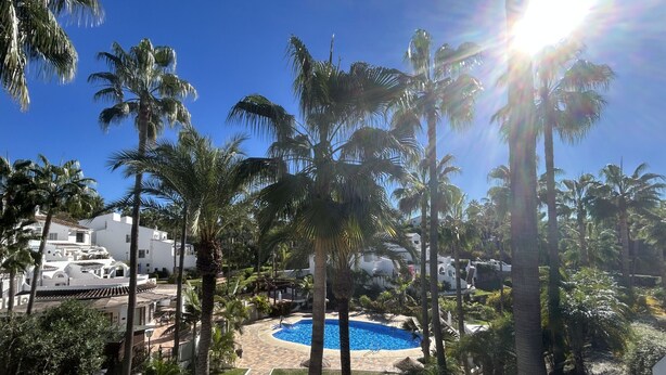 A resort with a swimming pool, palm trees, and white buildings. - Rabat 23 in Oasis de Capistrano Nerja (Nerja)