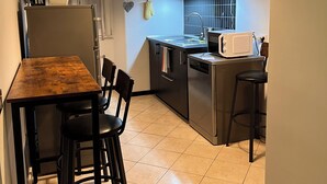 Una cocina compacta con una mesa de comedor, sillas, microondas y un lavabo.