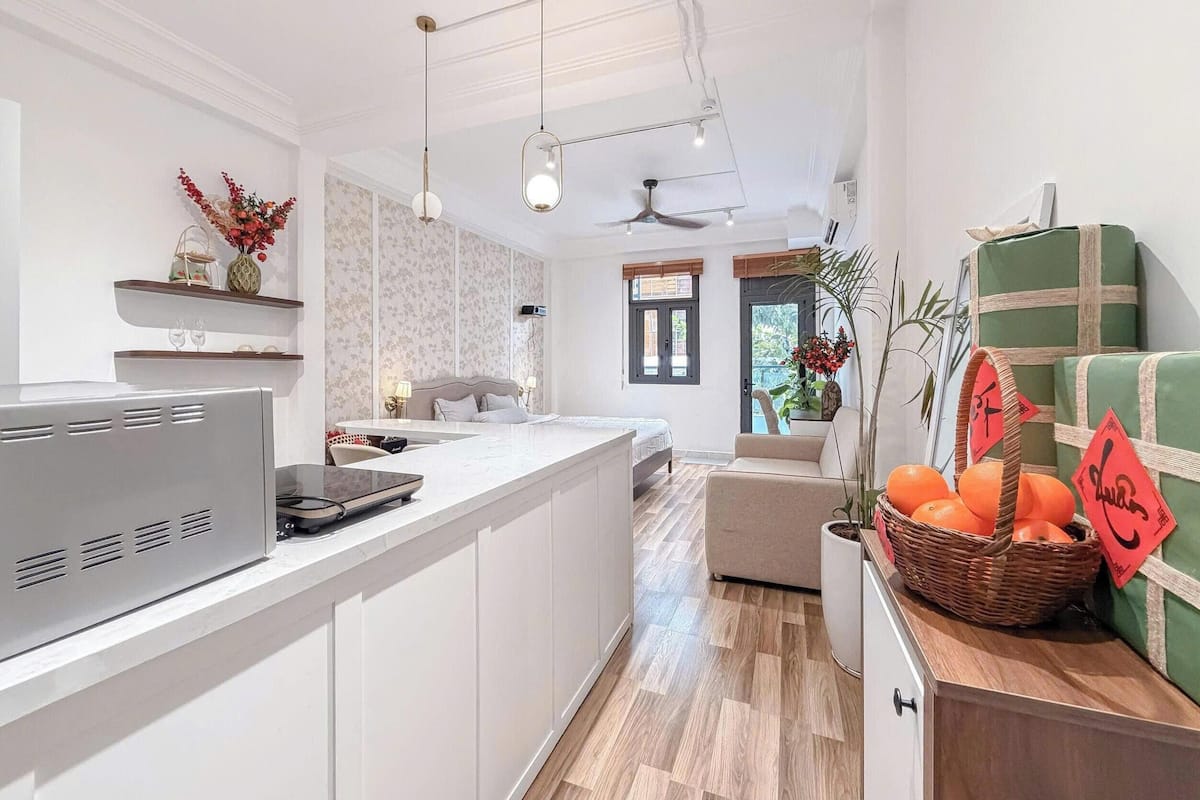 Una cocina moderna con una isla central, un área de comedor con sofá y vistas al exterior.
