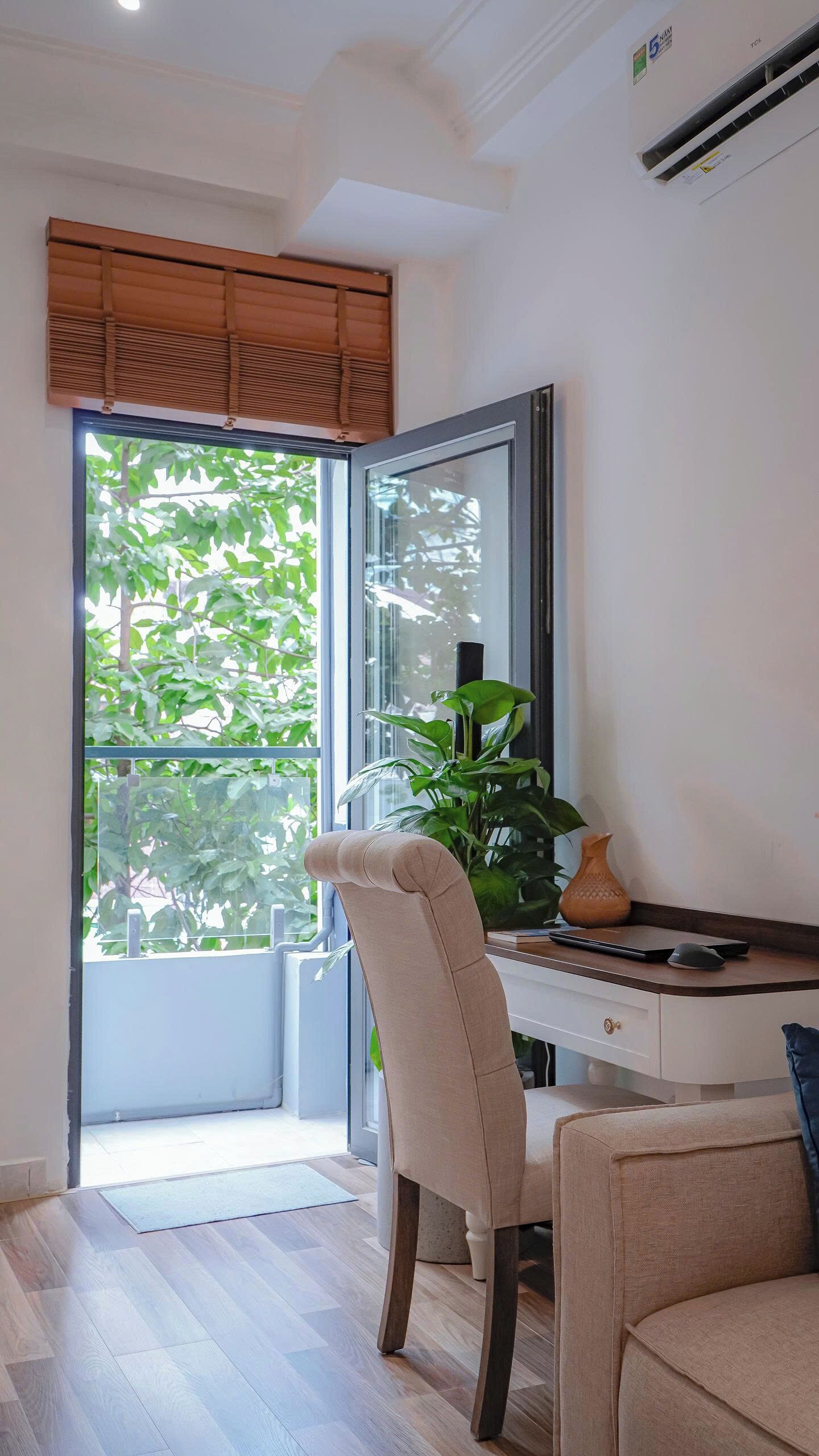 A modern room with a desk, chair, and a large window with a view of greenery.