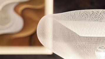 Un gros plan d’un objet blanc, à la texture marquée et au tissage apparent, qui pourrait être un meuble ou un élément de décoration.