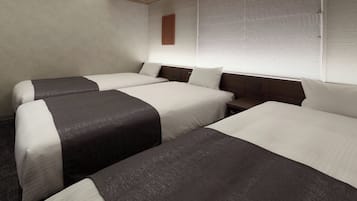Ein Hotelzimmer mit zwei Betten, einem Holzkopfteil, einem Nachttisch und einem Fenster mit Jalousien.