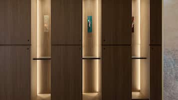 Una hilera de taquillas de madera con interiores iluminados y una obra de arte en la pared.