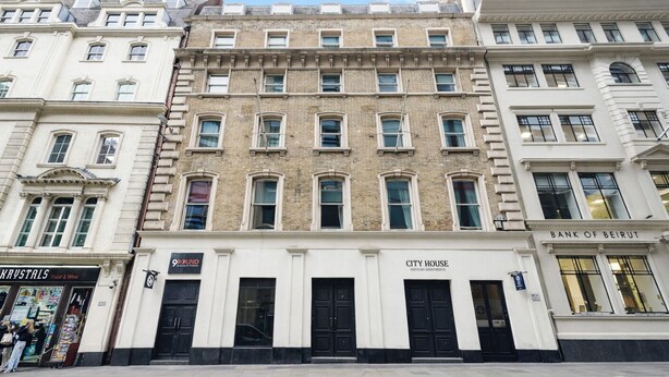 A multi-story building with a ground floor featuring a shop named '9ROUND' and a restaurant named 'KRYSTALS Food & Wine'. The building has a classic architectural style with a central entrance and a sign for 'CITY HOUSE' above the main doors. - Cannon Street Serviced Apartments (London)